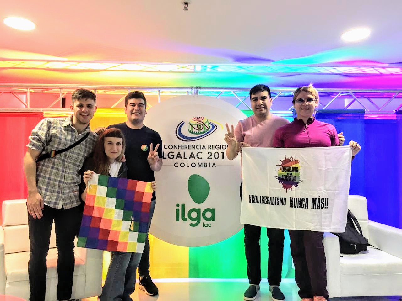 Participantes de la Conferencia Regional de ILGALAC 2019 posan con una wiphala y una bandera anticolonial.