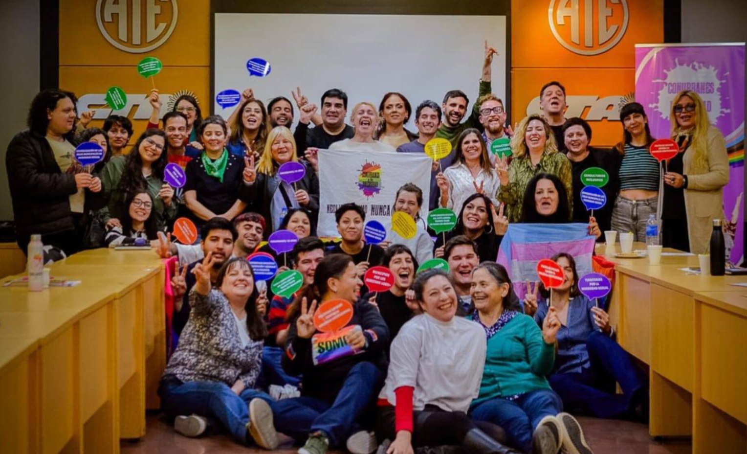 Grupo de participantes posa con carteles durante una actividad de Orgullo Bonaerense en la sede de ATE Nacional.